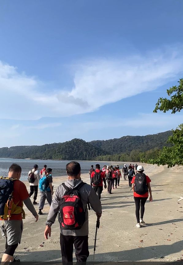 Daa Travel Asia 爬山团队走在 Mersing 海边沙滩上
